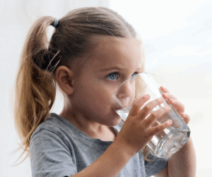 Young girl drinking glass of water.